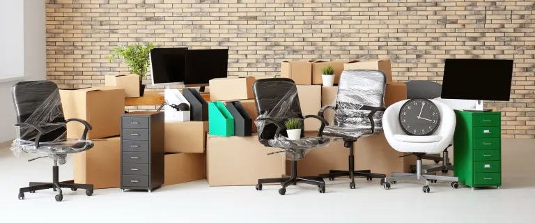 Packed office furniture, desks, chairs, and computers are ready for transport by the best movers in Dubai.