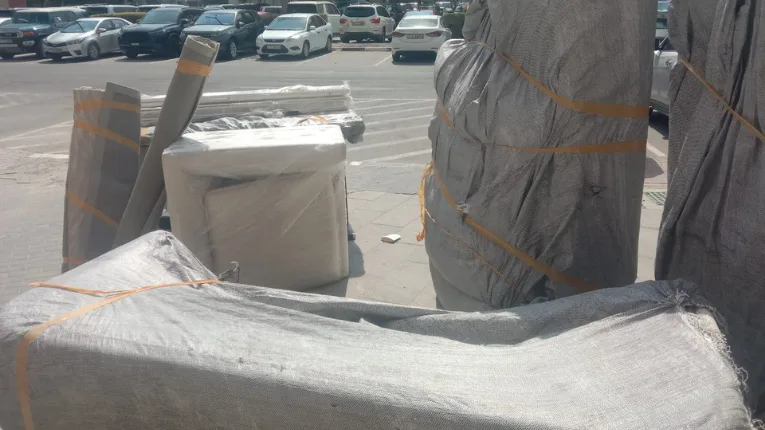 Movers and Packers in Dubai Marina 1 Packed household items wrapped and ready for transport in Dubai Marina, illustrating careful movers preparing furniture and boxes for relocation.