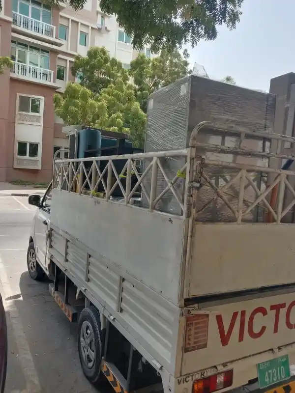 Professional movers in JVC loading wrapped furniture into a moving truck for secure relocation services
