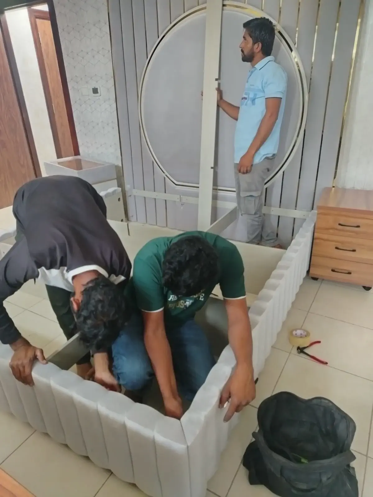 Trained moving crew carefully assembling bedroom furniture during a residential move in Dubai Silicon Oasis